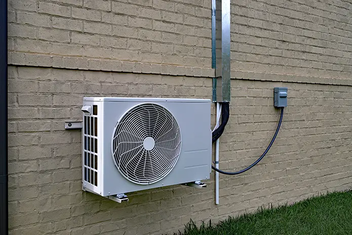 Ductless mini-split air conditioner on the side of a house